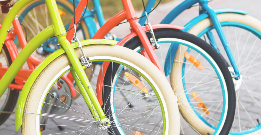 Close up of vibrant green, pink, and teal bicycles.