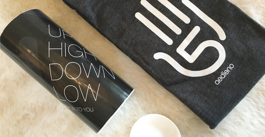 Aedieno five year “high-5” anniversary shirt and accompanying cylindrical packaging featuring copy that reads, “Up High Down Low.”